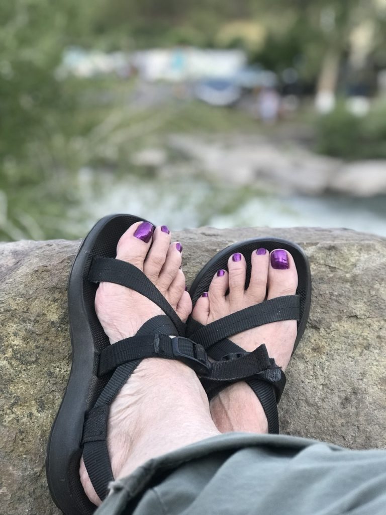 Woman in sandals on riverbank