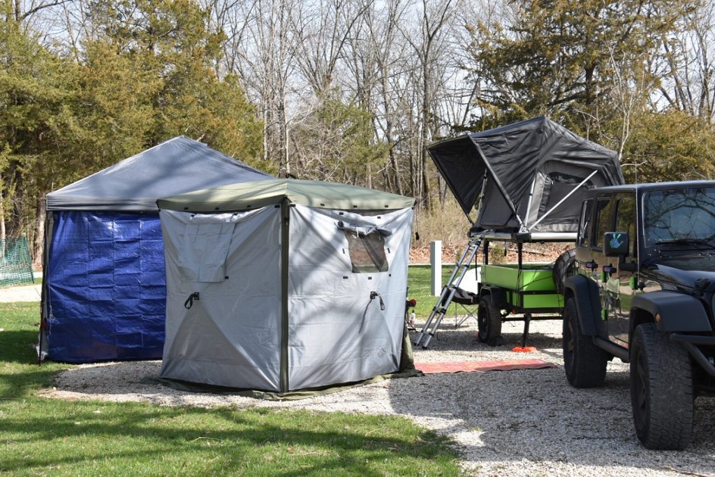 A campsite with a Jeep, a lime-green adventure cargo trailer with a roof top tent.