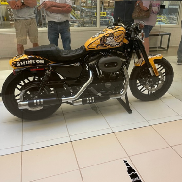 A Harley-Davidson Motorcycle made with Shiner Beer Images in black, yellow, gold and red painted on decals.