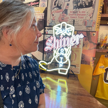 Lisa Dempsey looks across the wall at the posters and images in the Shiner Hall of Fame Room.