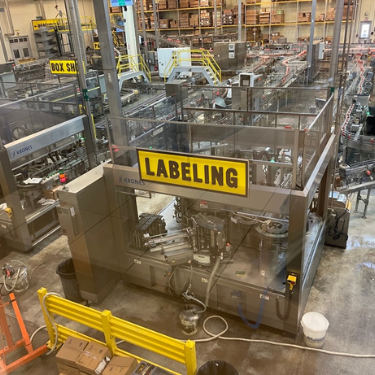 The manufacturing floor shows the labeling machine for the bottels of beer and spritzers being made at the brewery