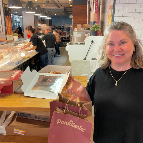 Lisa Dempsey holding several shopping bags full of pastry at La Panadaria in San Antonio and pan de muerto