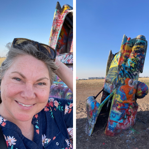 Lisa Dempsey with a graffiti painted car half submerged in the ground at the Cadillac Ranch in Amarillo