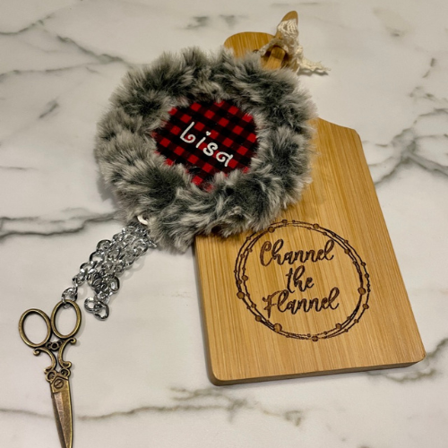 Name badge with fur trim and small cutting board marked with Channel the Flannel