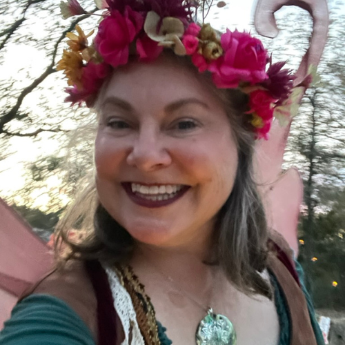 Lisa Dempsey with a flower garland headband and large pink wings in a fairy costume