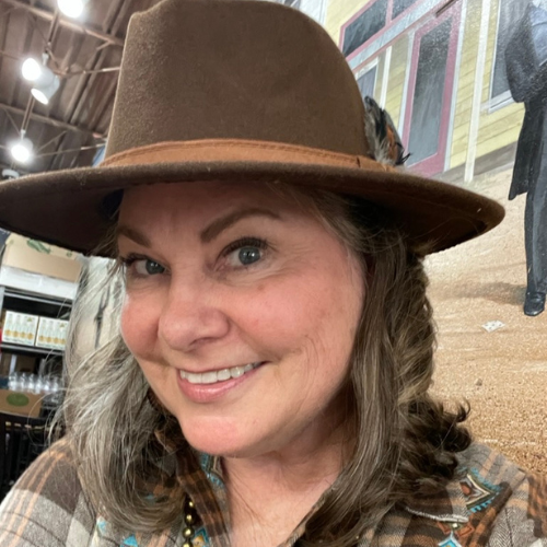 Lisa Dempsey in a brown felt had with a feather in the headbanc in Fredericksburg, TX at the Sip Sip Hooray event