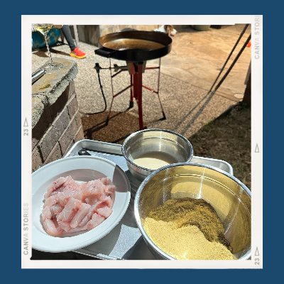 The Firedisc Cooker is in the background with oil heating to cook the fish tacos.  In the foreground are three bowls of fish, egg wash, and cornmeal dredge.