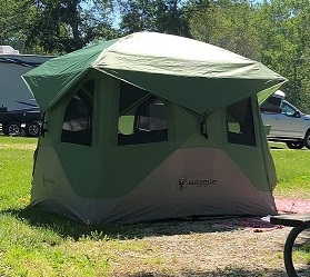An alpine green hub tent in a campground.