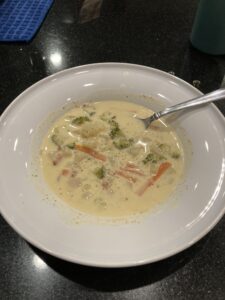 Shows a bowl of homemade broccoli cheese soup